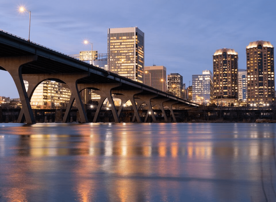 bridge over water near city buildings during night time